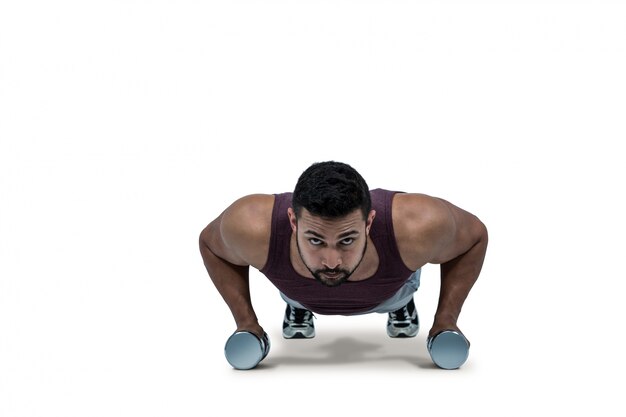 Muscular man doing push ups with dumbbells