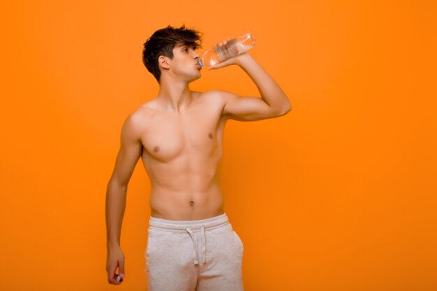 Acqua potabile dell'uomo muscolare dalla bottiglia