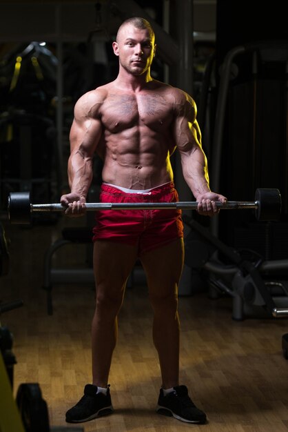 Muscular Man Exercising Biceps With Barbell