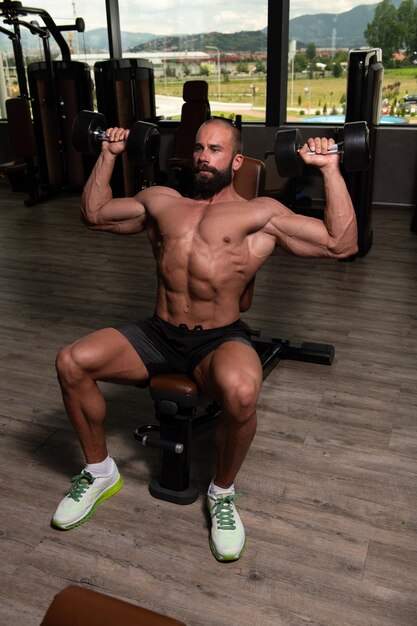 Muscular Man Exercising Shoulders With Dumbbell