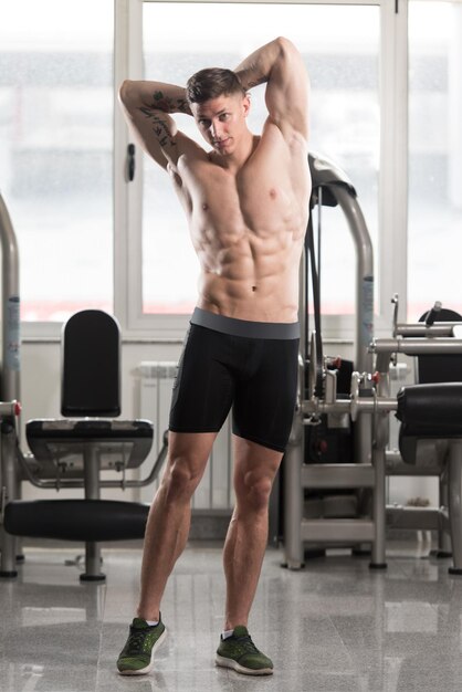 Muscular Man Flexing Muscles In Gym