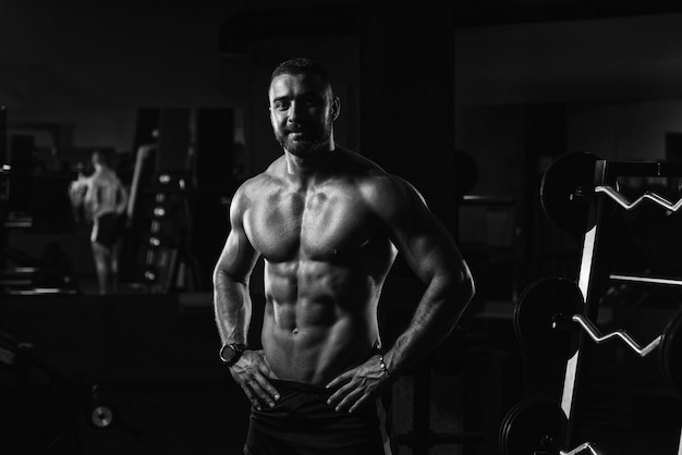 Muscular Man Flexing Muscles In Gym