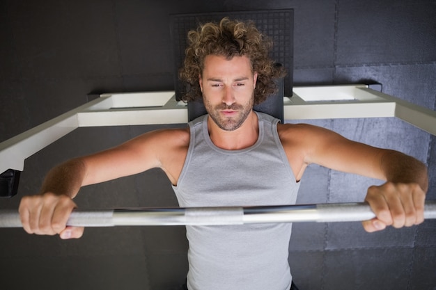 Foto bilanciere di sollevamento dell'uomo muscolare in palestra