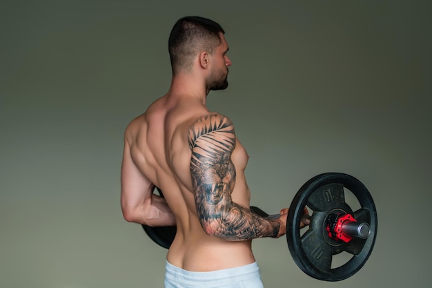 Photo muscular man lifting weights at gym handsome guy prepare to do exercises with dumbbell