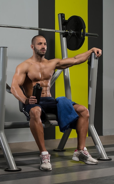 Muscular Man Resting After Exercise And Drinking From Shaker