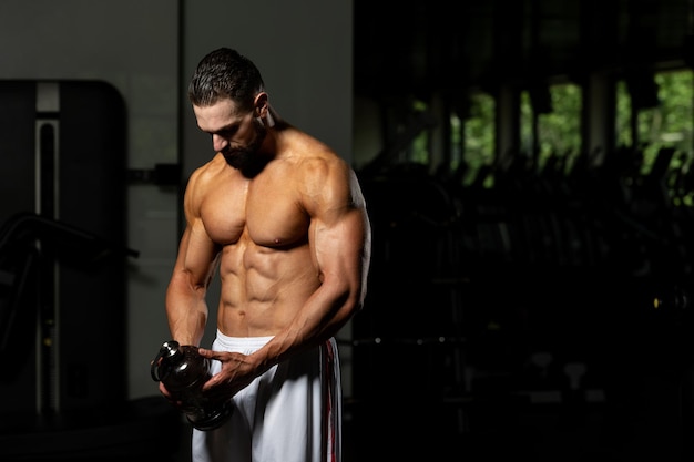 Muscular Man Resting After Exercise And Drinking From Shaker