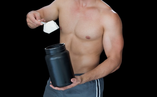 Muscular man scooping up protein powder