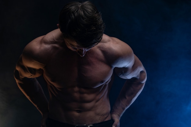 Muscular man showing muscles isolated on the black backgroundhealthy lifestyle