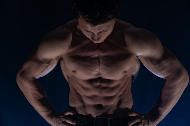 Muscular man showing muscles isolated on the black backgroundhealthy lifestyle