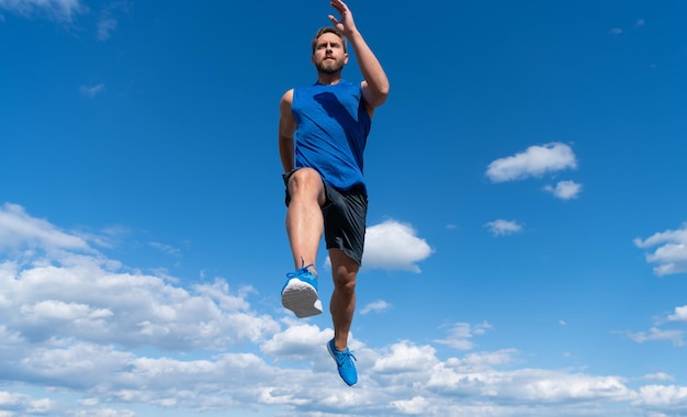 空の背景、マラソンで屋外スポーツウェアで実行されている筋肉の男のスプリンター