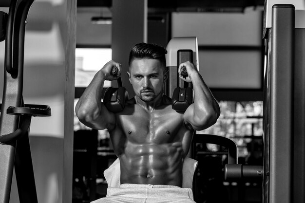 Photo muscular man training in gym