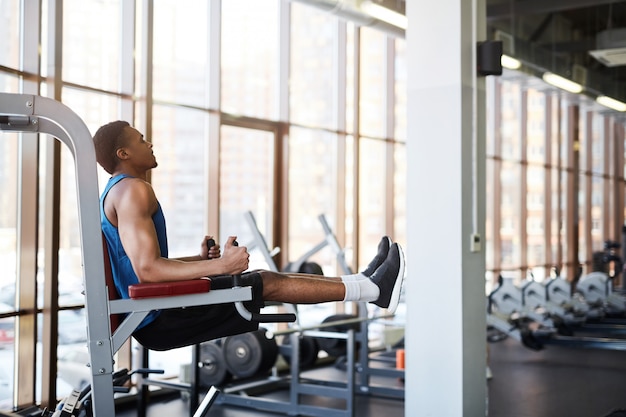 Muscular Man using Machines in Gym