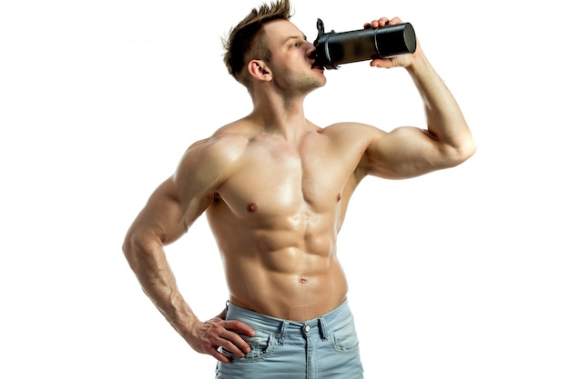 Muscular man with protein drink in shaker over white background