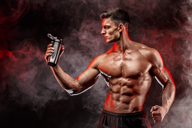 Muscular man with protein drink in shaker