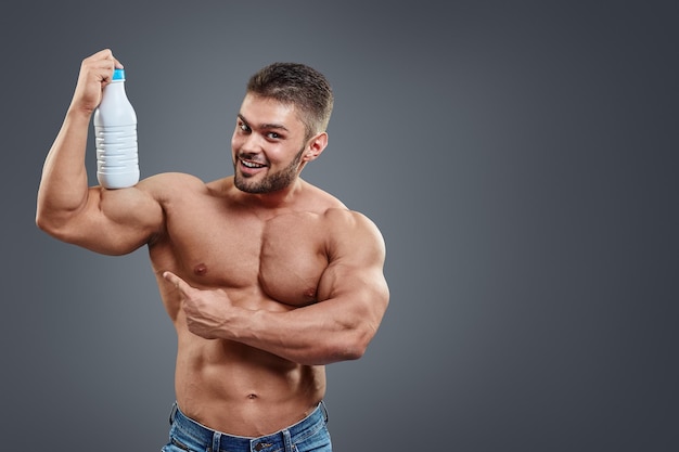 Мускулистый мужчина с протеиновым напитком в шейкере