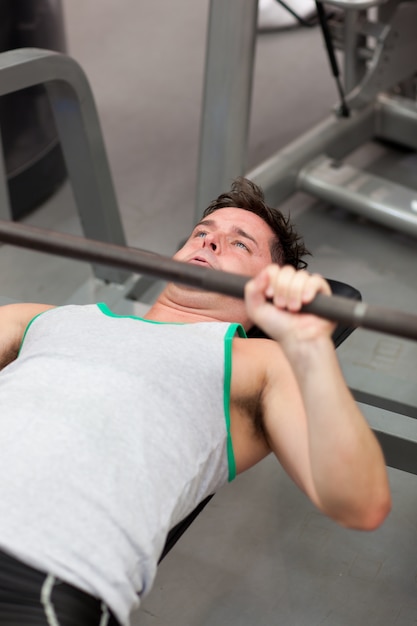 Muscular man working out with dumbbells