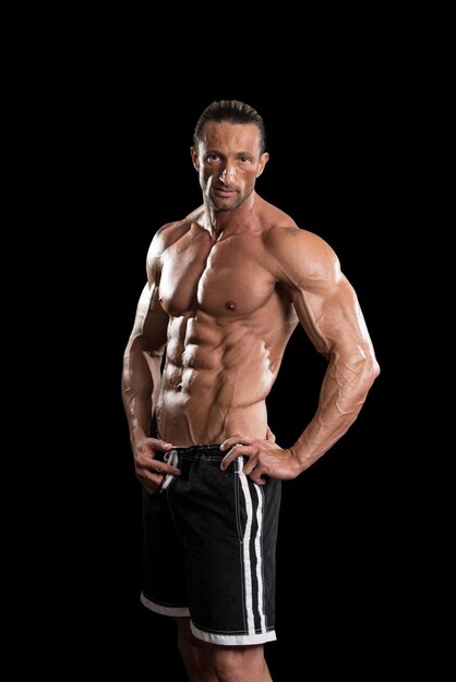 Muscular Mature Man Posing In Studio  Isolated On Black Background