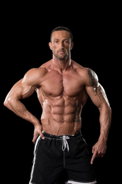 Muscular Mature Man Posing In Studio  Isolated On Black Background