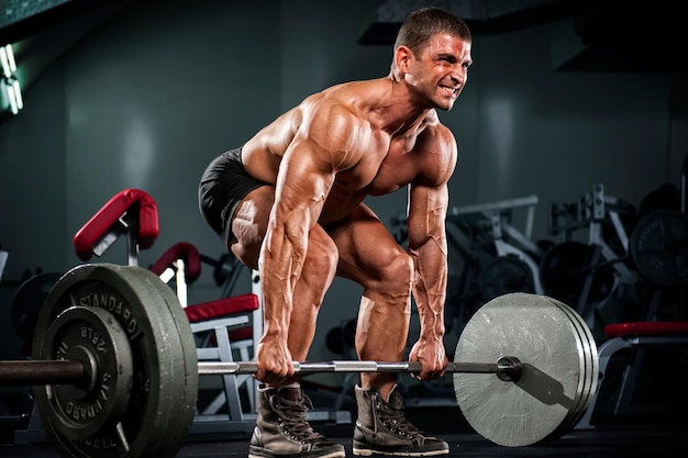 Muscular Men Lifting heavy weights performing dead lift exercise