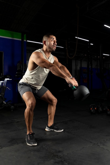 Muscular mexican man swinging a kettlebell