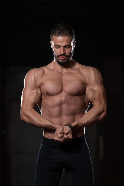 Muscular Model Flexing Muscles In Gym