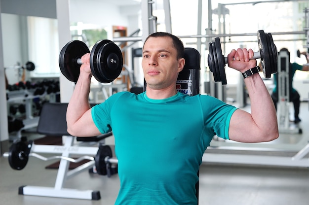 Photo muscular ripped bodybuilder with dumbbells