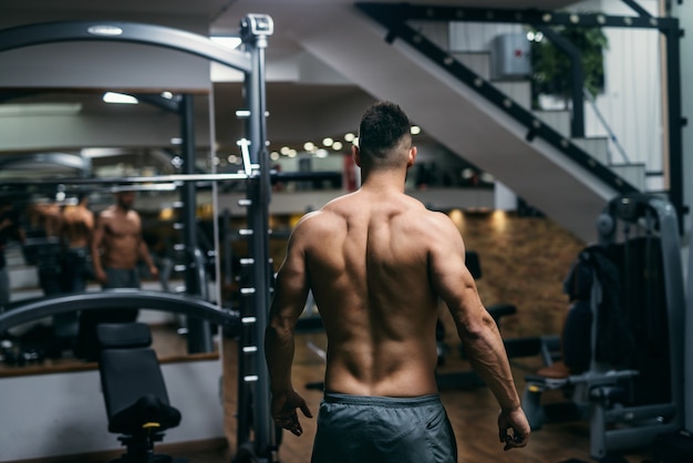 Muscular shirtless man posing in the gym