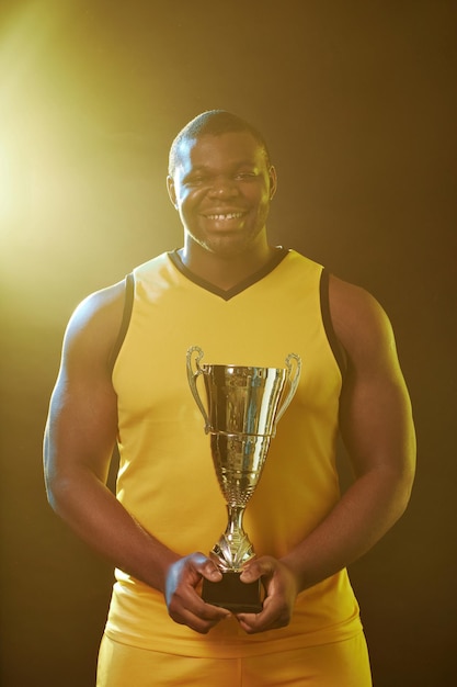 Muscular sportsman smiling at camera celebrating victory