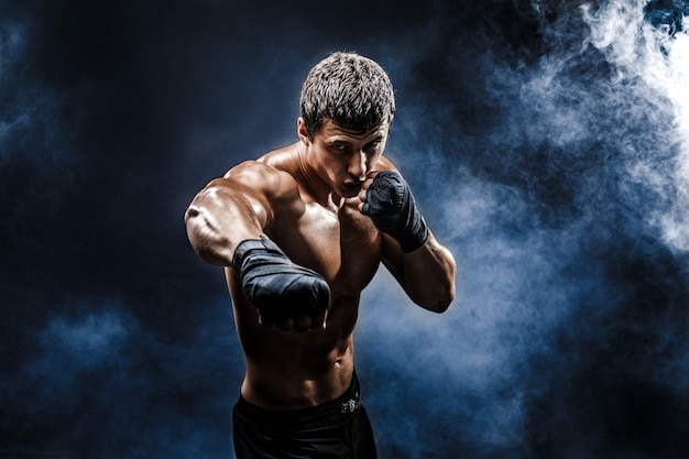 Photo muscular topless fighter in boxing gloves