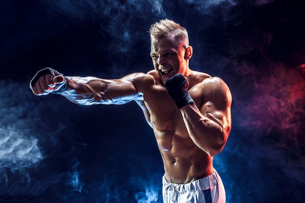 Muscular topless fighter in boxing gloves