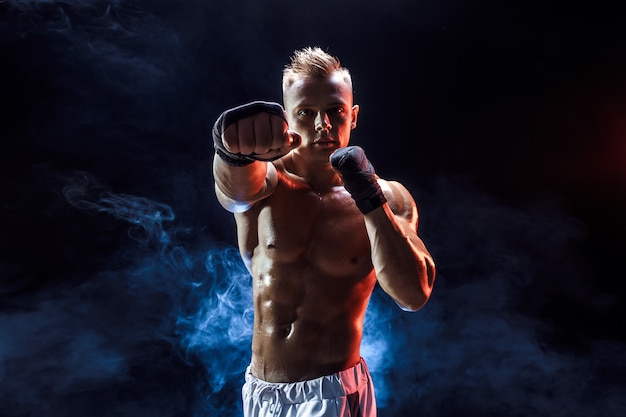 Muscular topless fighter in boxing gloves