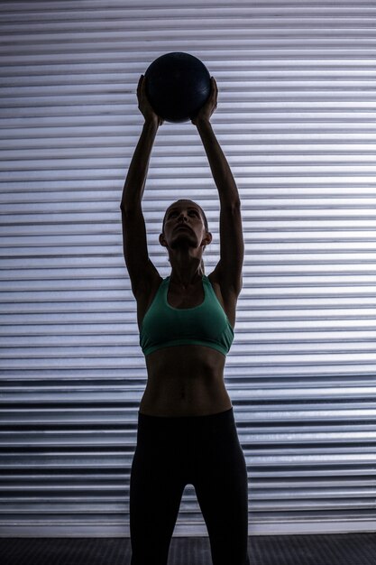 Muscular woman doing ball exercise