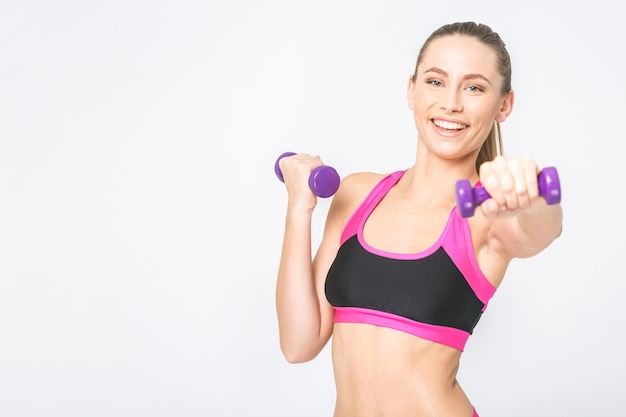 Muscular woman doing exercises with dumbbells