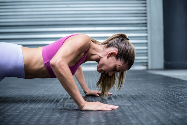 Photo muscular woman doing push ups