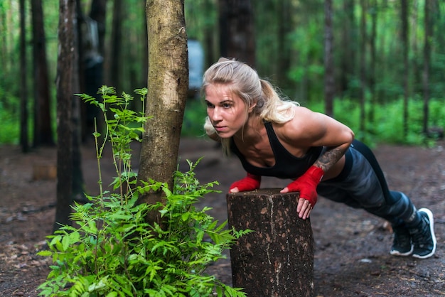 Muscular woman doing pushups at park street work out