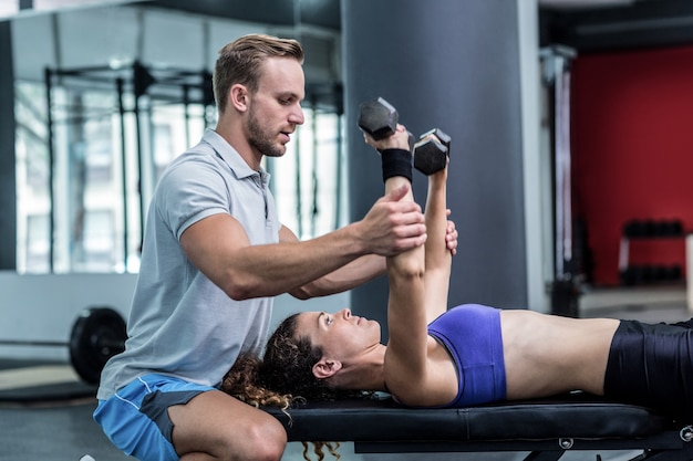 Una donna muscolare che alza i dumbbells