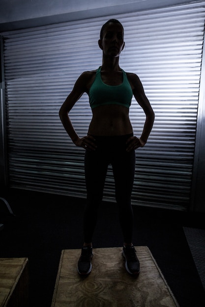 Muscular woman standing on a box