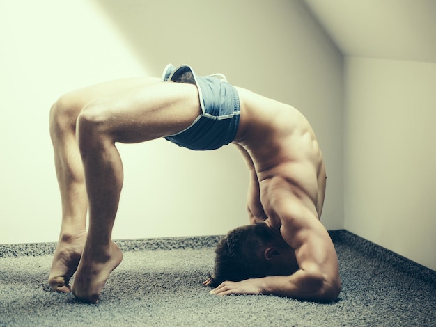 Muscular yoga man in bridge position