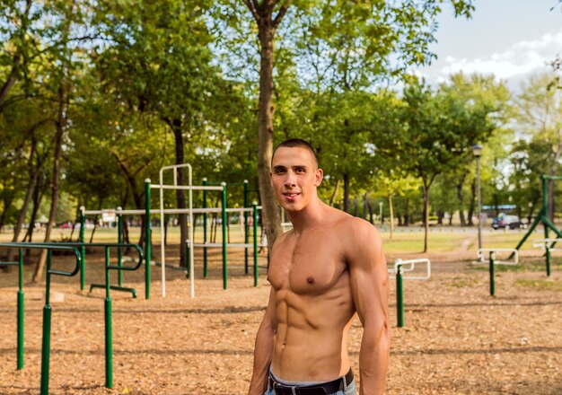 Muscular young man during his workout on the street. Fit, fitness, workout, exercise