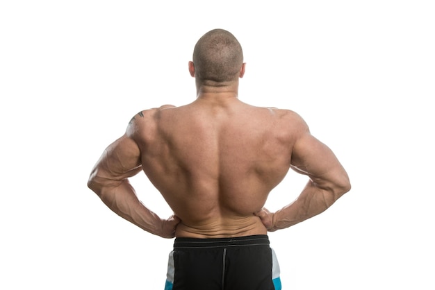 Photo muscular young man posing in studio  isolated on white background