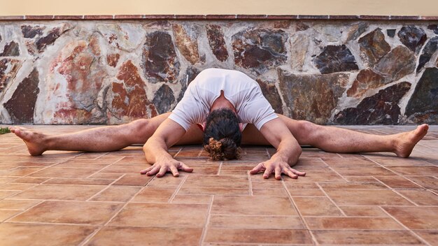 Photo muscular young man stretching at home. home workout concept and healthy living.