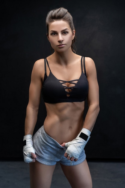 Muscular young woman athlete standing isolated