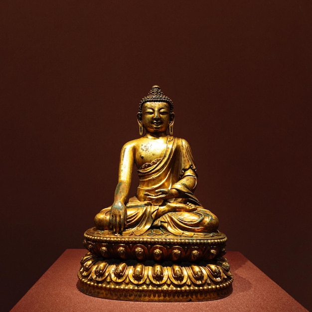 A museum exhibit of an antique buddha sculpture in the lotus position representing enlightenment and