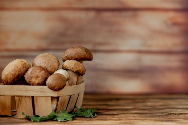 木製の背景にキノコのポルチーニ。秋のセップ茸。木製の背景上のCeps Boletus edulisは、木製の素朴なテーブルにクローズアップ。おいしい有機きのこを調理しています。グルメ食品。