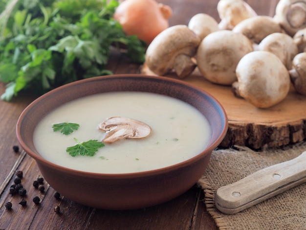 Mushroom cream soup with fresh champignons in a ceramic plate