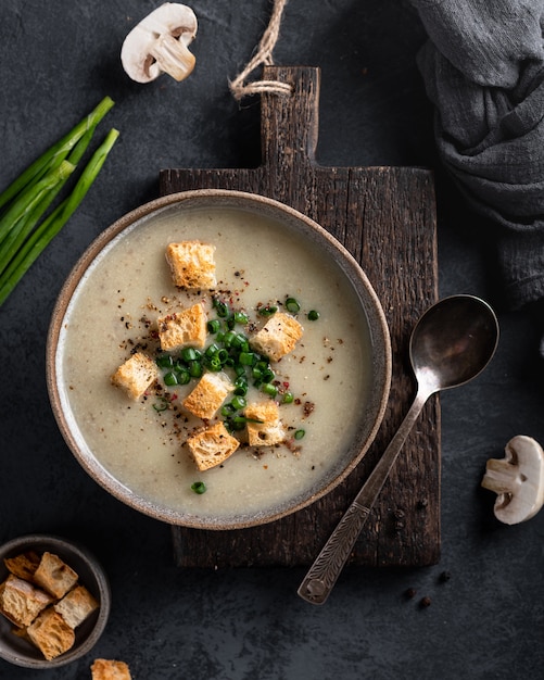mushroom cream soup with mushrooms and croutons in a ceramic bowl