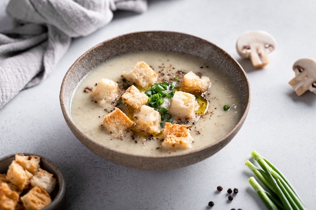 Mushroom cream soup with mushrooms and croutons in a ceramic bowl