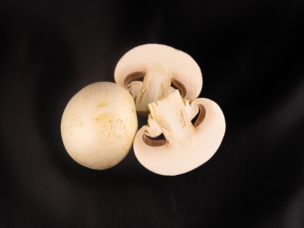 Mushroom mushroom and two halves close up on a dark background