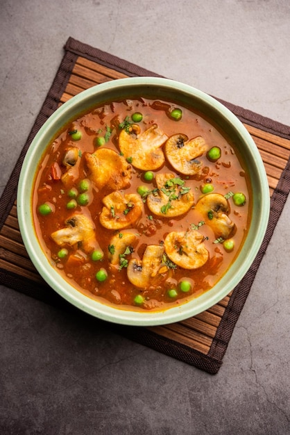 Photo mushroom and pea curry with roasted garlic indian food served in a bowl