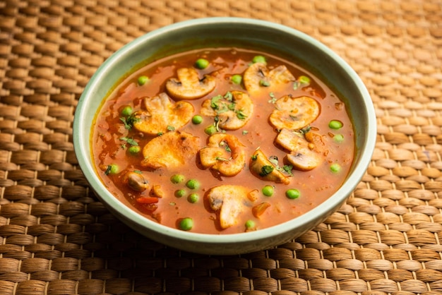 Photo mushroom and pea curry with roasted garlic indian food served in a bowl